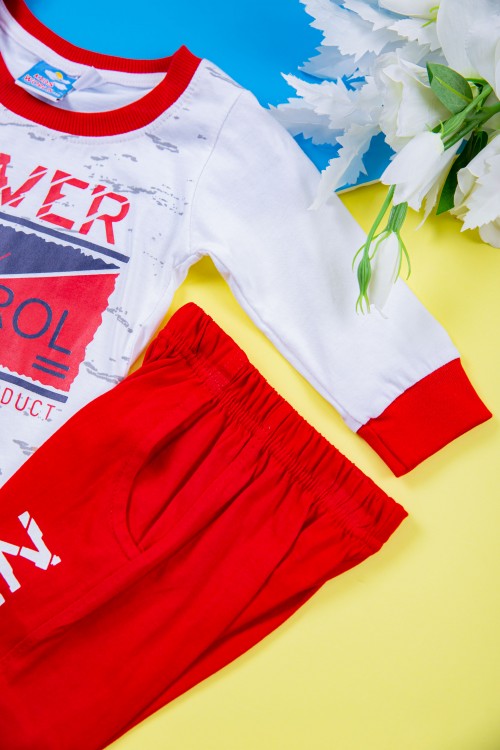 طقم ولادي قطعتين بلوزة لون أبيض مزينة بكتابات و رسومات من الأمام مع بنطلون طويل لون أحمر بكتابات و جيوب من الجانبين و زم في الأطراف