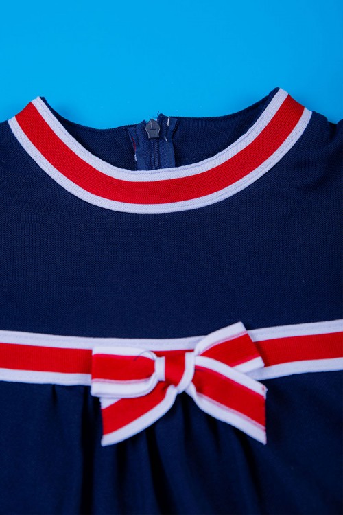 فستان بناتي متعدد الاوان بأكمام قصيرة و ياقة عالية مزينة باللون الأحمر و الكحلي و بفيونكة في الوسط بسحاب مخفي من الخلف