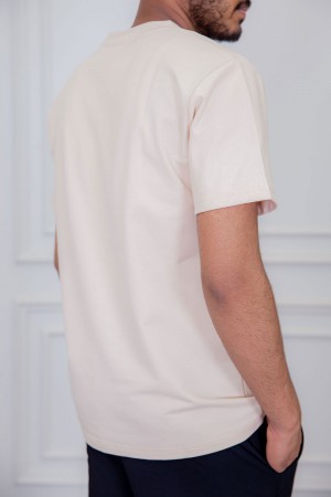 تيشيرت رجالي لون بيج مزين بكتابات و رسومات ملونة من الأمام