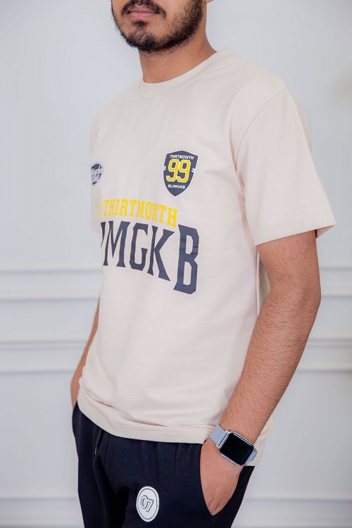 تيشيرت رجالي لون بيج مزين بكتابات و رسومات ملونة من الأمام