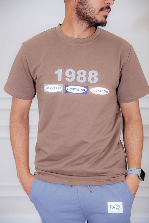 تيشيرت رجالي لون بني فاتح  مزين بكتابات ملونة من الأمام