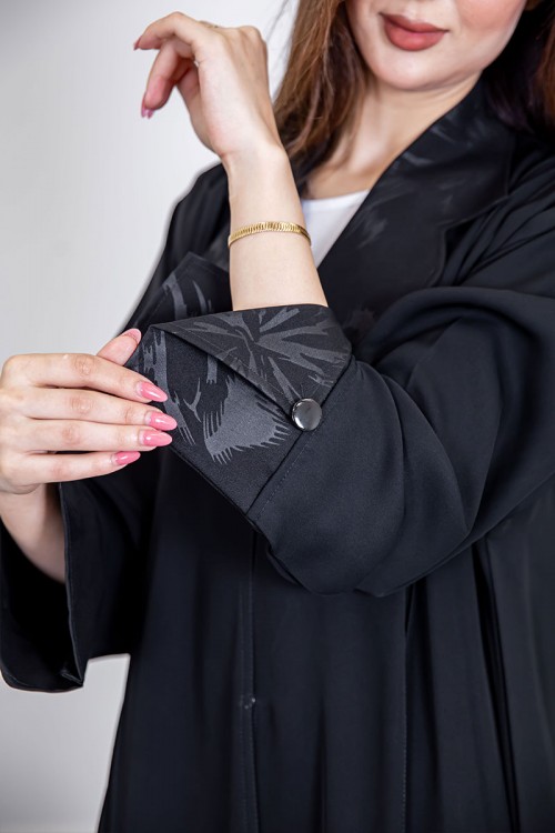 عباية نسائية أنيقة لون أسود ياقة مطوية مزينة بنقوش في الياقة و أطراف الأكمام بأزرار من الأمام مع طرحة