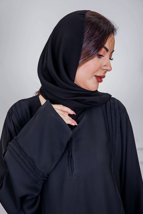 عباية نسائية أنيقة لون أسود ياقة دائرية بأزرار مزينة بطيات طويلة مغلقة من الأمام مع طرحة