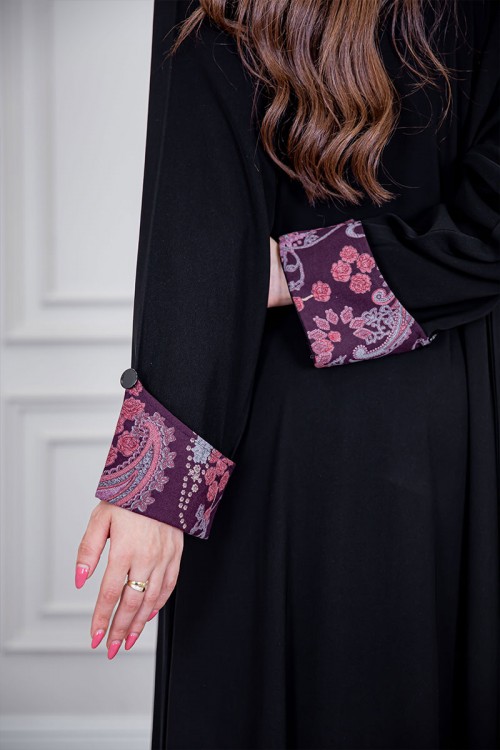 عباية نسائية أنيقة لون أسود ياقة قصة سبعة بأزرار من الأمام مزينة بطيات طويلة ملونة و من أطراف الأكمام مع طرحة