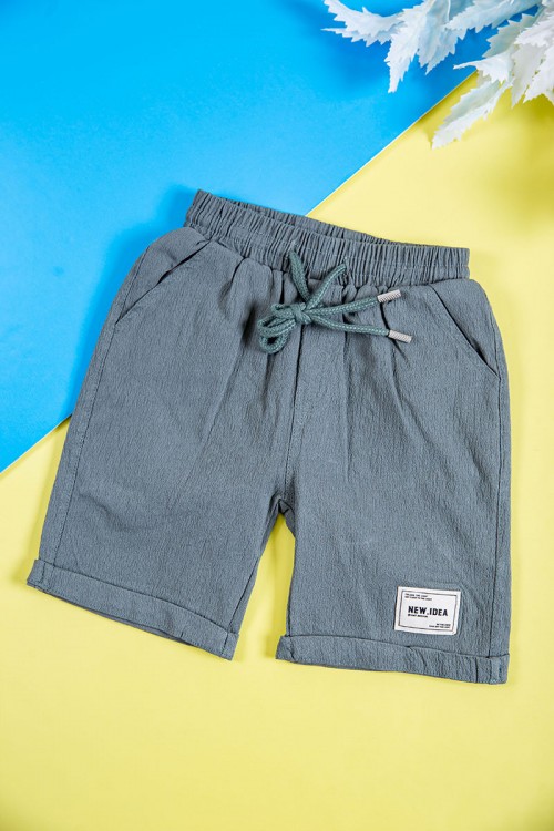 طقم ولادي قطعتين لون رصاصي قميص بكتابات و طبعات وجيوب وازرار من الأمام و شورت برباط في الخصر و جيوب من الجانبين و الخلف