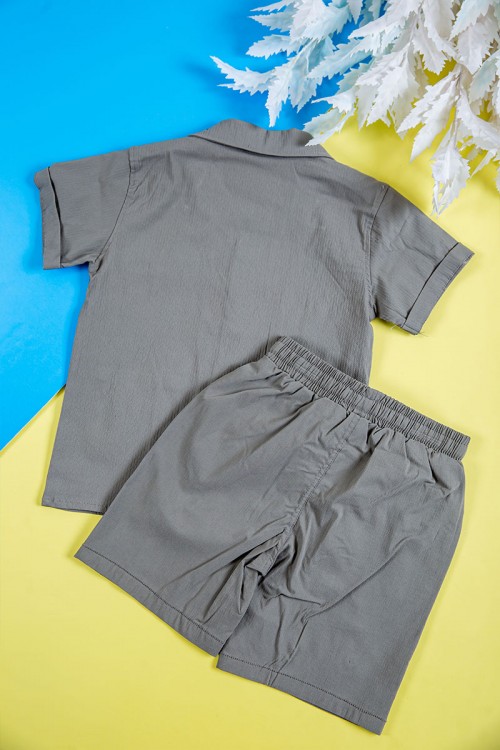 طقم ولادي قطعتين لون رمادي قميص بكتابات و طبعات وجيوب وازرار من الأمام و شورت برباط في الخصر و جيوب من الجانبين و الخلف