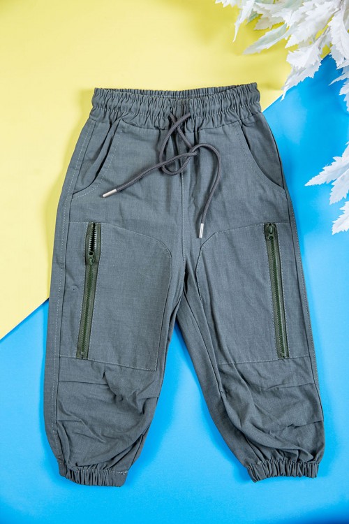 طقم ولادي قطعتين بلوزة لون بيج فاتح بكتابات و طبعات و أزرار و جيب من الأمام و بنطلون طويل لون رصاصي برباط في الخصر و جيوب و سحاب من الجانبين