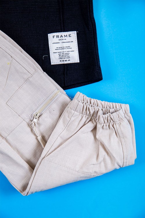 طقم ولادي قطعتين بلوزة لون أسود بطبعات و أزرار من الأمام و الأكمام و بنطلون طويل لون بيج فاتح برباط في الخصر و جيوب و سحاب من الجانبين