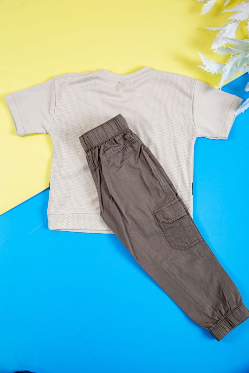 طقم ولادي قطعتين تيشيرت لون بيج فاتح بكتابات و طبعات من الأمام و بنطلون طويل لون بني بجيوب من الجانبين