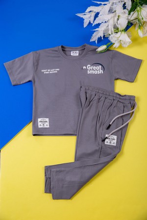 طقم ولادي قطعتين لون رصاصي تيشيرت بكتابات و طبعات من الأمام و الخلف و بنطلون طويل برباط في الخصر و جيوب من الجانبين