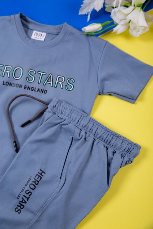 طقم ولادي قطعتين لون أزرق تيشيرت بكتابات و طبعات من الأمام و بنطلون طويل برباط في الخصر و جيوب من الجانبين وزم في الأسفل