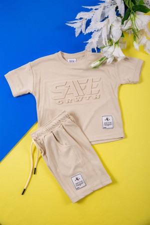 طقم ولادي قطعتين لون بيج تيشيرت بكتابات و طبعات من الأمام و شورت برباط في الخصر و جيوب من الجانبين