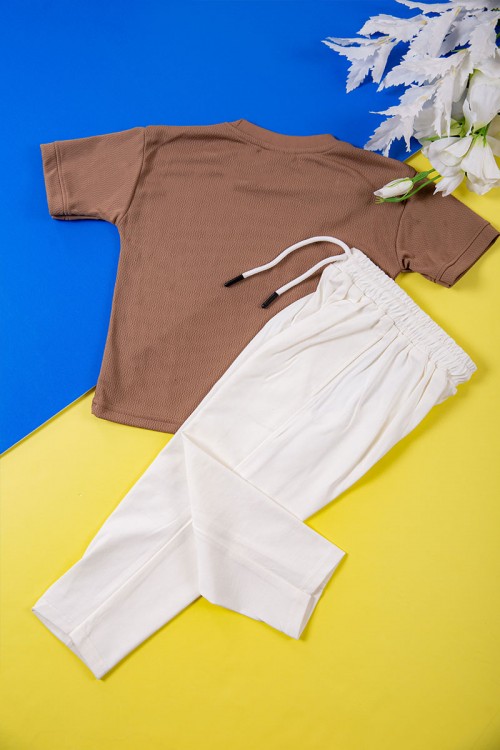 طقم ولادي قطعتين تيشيرت لون بني بكتابات و طبعات من الأمام و بنطلون طويل لون سكري برباط في الخصر و جيب من الجنب