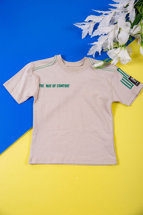 طقم ولادي قطعتين لون بيج تيشيرت بكتابات باللون الأخضر و طبعات و بنطلون طويل برباط في الخصر و جيوب من الجانبين وزم في الأسفل