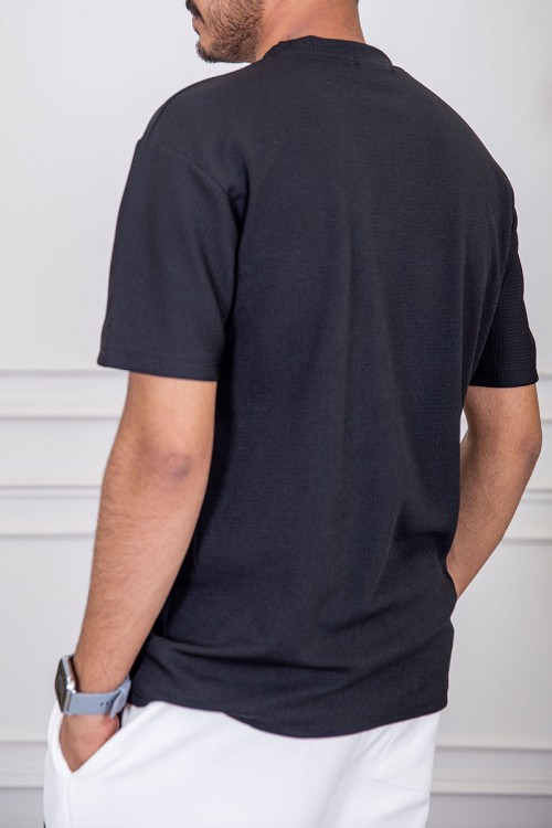 تيشيرت رجالي لون أسود بياقة دائرية مزين بكتابات من الأمام