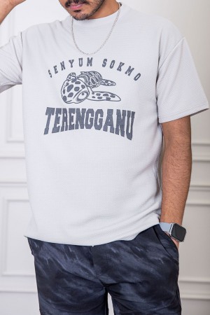 تيشيرت رجالي لون رمادي فاتح بياقة دائرية مزين بكتابات و رسومات من الأمام