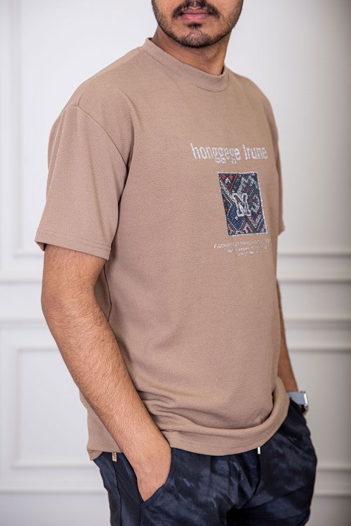 تيشيرت رجالي لون بيج غامق بياقة دائرية مزين بكتابات و طبعات من الأمام