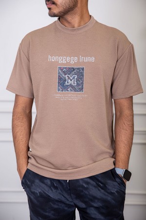 تيشيرت رجالي لون بيج غامق بياقة دائرية مزين بكتابات و طبعات من الأمام