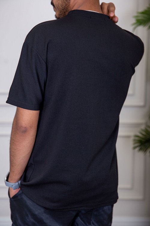 تيشيرت رجالي لون أسود بياقة دائرية مزين بكتابات من الأمام