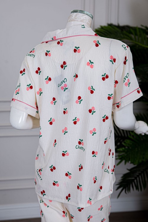 بيجاما نسائية قطعتين لون بيج مزينة برسومات بلوزة بياقة مطوية و بجيب و أزرار من الأمام مع بنطلون طويل