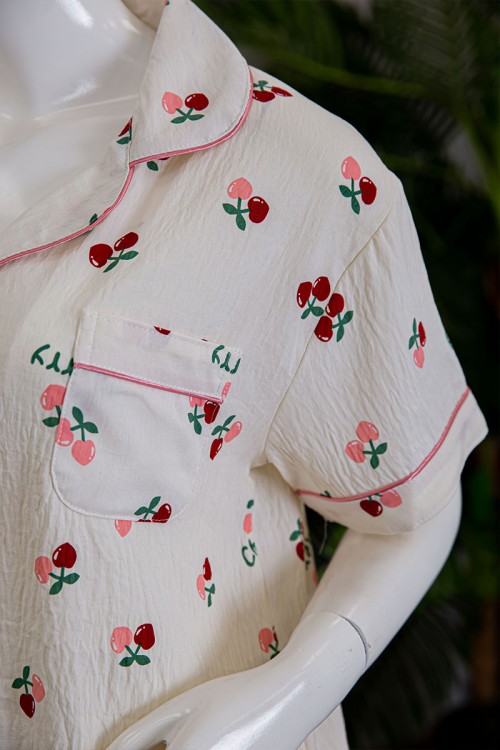 بيجاما نسائية قطعتين لون بيج مزينة برسومات بلوزة بياقة مطوية و بجيب و أزرار من الأمام مع بنطلون طويل