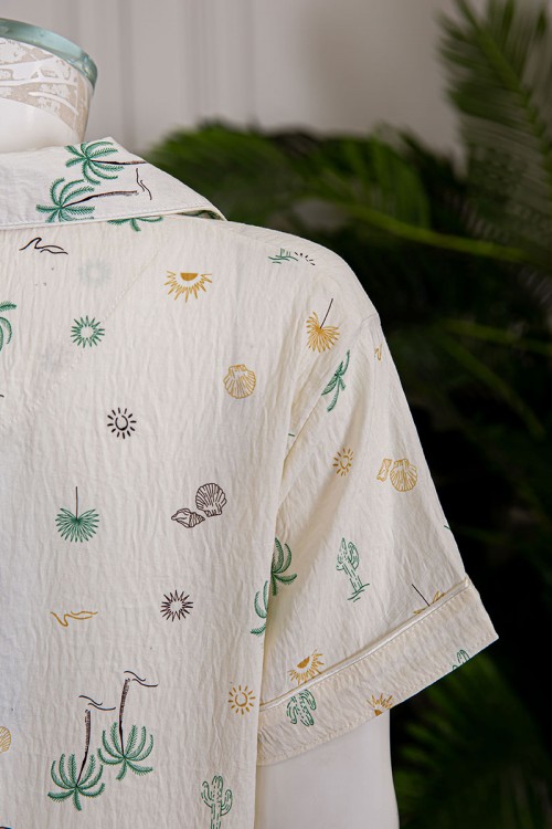 بيجاما نسائية قطعتين لون بيج مزينة برسومات بلوزة بياقة مطوية و بجيب و أزرار من الأمام مع بنطلون طويل