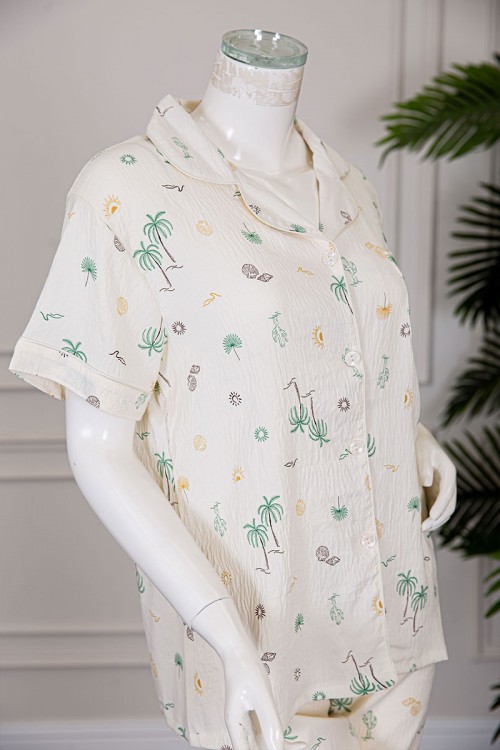 بيجاما نسائية قطعتين لون بيج مزينة برسومات بلوزة بياقة مطوية و بجيب و أزرار من الأمام مع بنطلون طويل