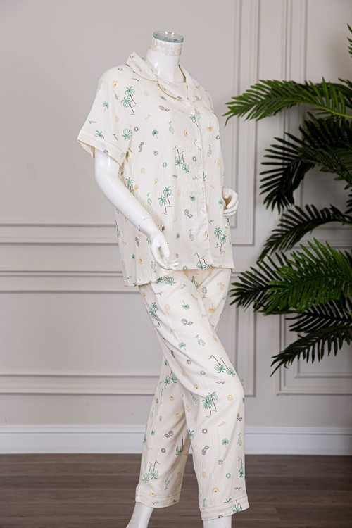 بيجاما نسائية قطعتين لون بيج مزينة برسومات بلوزة بياقة مطوية و بجيب و أزرار من الأمام مع بنطلون طويل