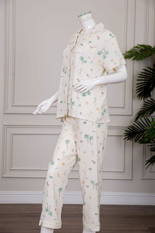 بيجاما نسائية قطعتين لون بيج مزينة برسومات بلوزة بياقة مطوية و بجيب و أزرار من الأمام مع بنطلون طويل