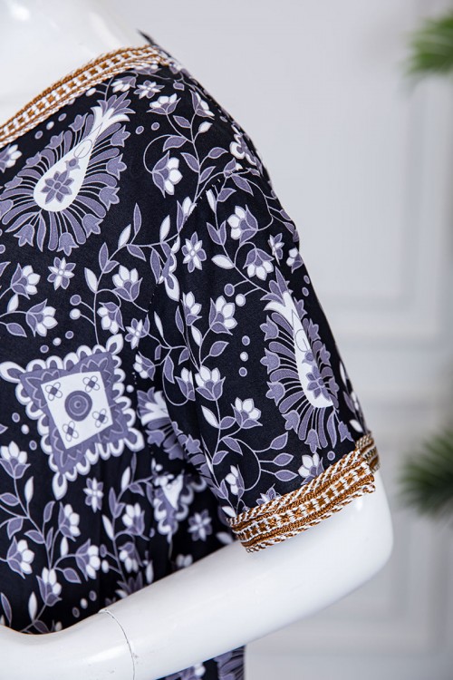 قميص نسائي طويل لون أسود مزين برسومات باللون الرمادي و بكلفة بيج مطرزة باللون الذهبي في الياقة و الأكمام