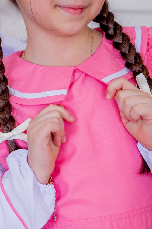 مريول بناتي مدرسي لون وردي مع قميص أبيض متصل و بأكتاف كرانيش و جيوب من الجانبين و رباط في الخصر