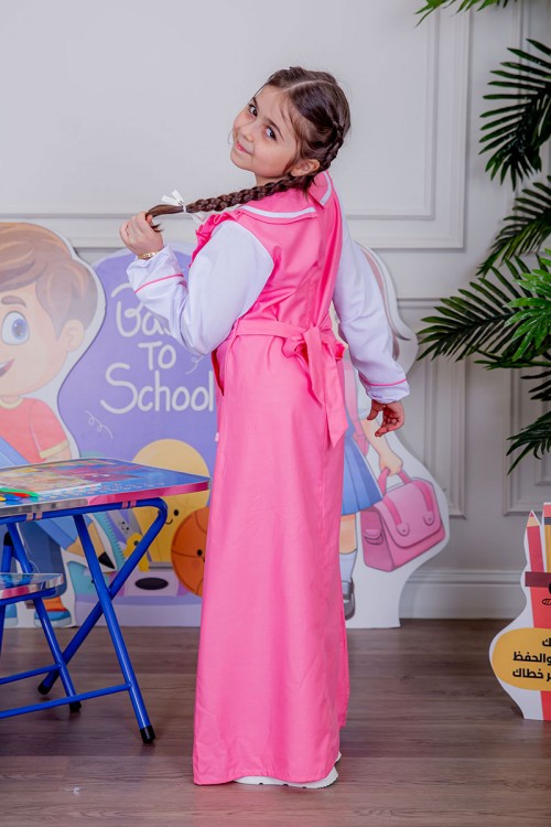 مريول بناتي مدرسي لون وردي مع قميص أبيض متصل و بأكتاف كرانيش و جيوب من الجانبين و رباط في الخصر