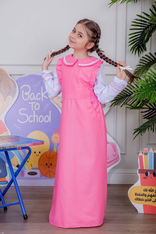 مريول بناتي مدرسي لون وردي مع قميص أبيض متصل و بأكتاف كرانيش و جيوب من الجانبين و رباط في الخصر