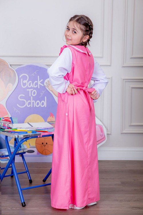 مريول بناتي مدرسي لون وردي مع قميص أبيض متصل و بأكتاف كرانيش و جيوب من الجانبين و رباط في الخصر