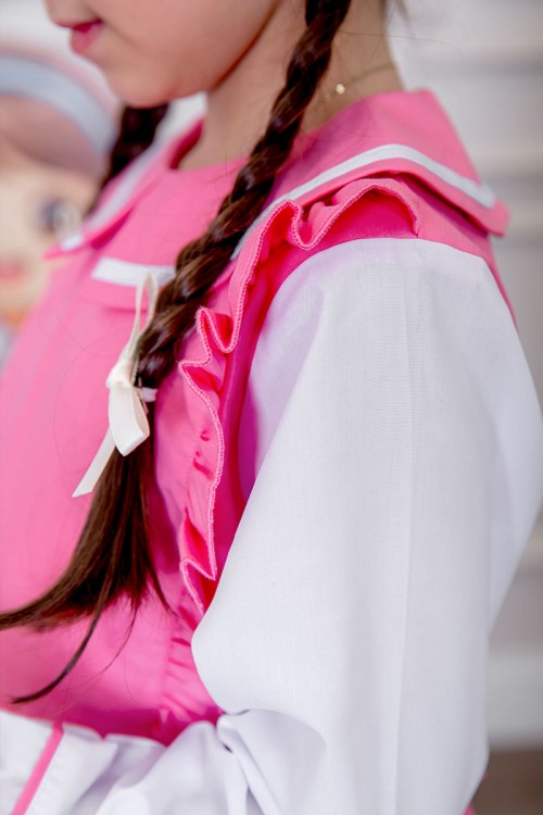 مريول بناتي مدرسي لون وردي مع قميص أبيض متصل و بأكتاف كرانيش و جيوب من الجانبين و رباط في الخصر