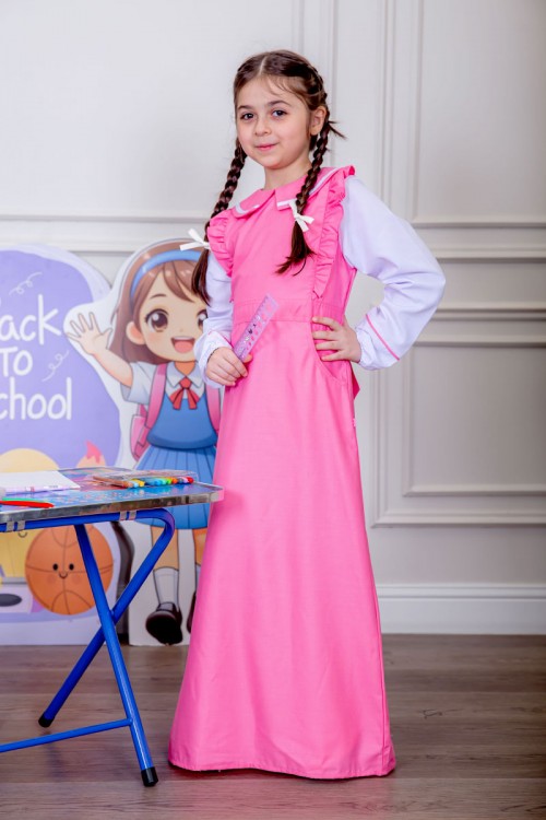 مريول بناتي مدرسي لون وردي مع قميص أبيض متصل و بأكتاف كرانيش و جيوب من الجانبين و رباط في الخصر