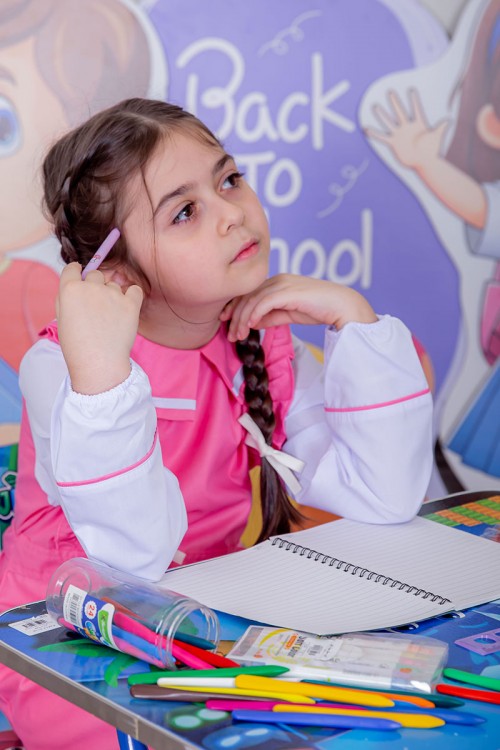 مريول بناتي مدرسي لون وردي مع قميص أبيض متصل و بأكتاف كرانيش و جيوب من الجانبين و رباط في الخصر