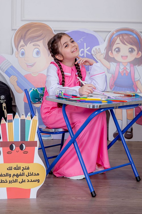 مريول بناتي مدرسي لون وردي مع قميص أبيض متصل و بأكتاف كرانيش و جيوب من الجانبين و رباط في الخصر