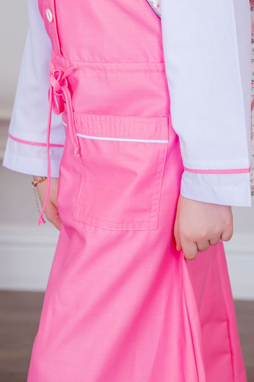 مريول بناتي مدرسي لون وردي مع قميص أبيض متصل بأزرار و جيوب من الأمام و رباط في الخصر