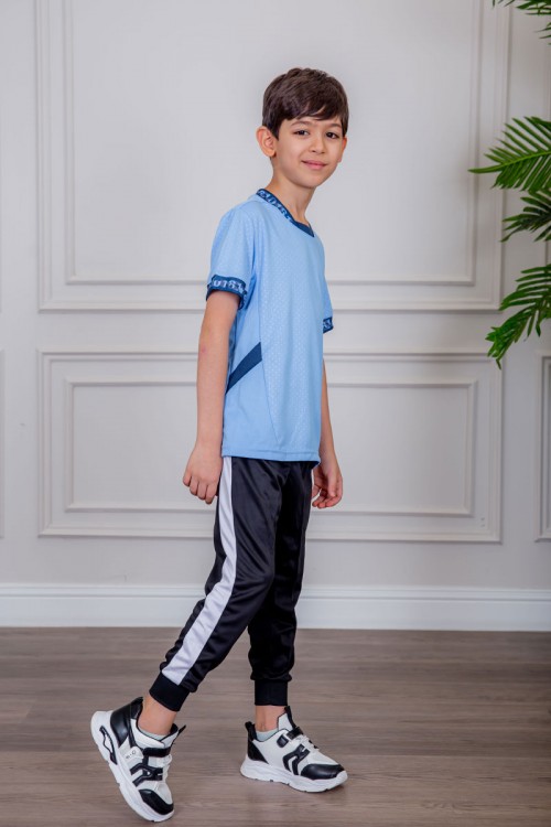 طقم ولادي رياضي قطعتين تيشيرت لون سماوي مقلم باللون الذهبي و بنطلون طويل لون أسود مخطط باللون الأحمر من الجانبين و بزم من الأسفل