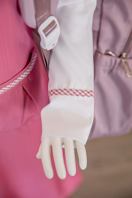 مريول بناتي مدرسي لون وردي مع قميص أبيض متصل بياقة مطوية و جيوب من الأمام و سحاب و رباط في الخلف