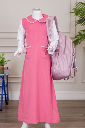 مريول بناتي مدرسي لون وردي مع قميص أبيض متصل بياقة مطوية و جيوب من الأمام و سحاب و رباط في الخلف 