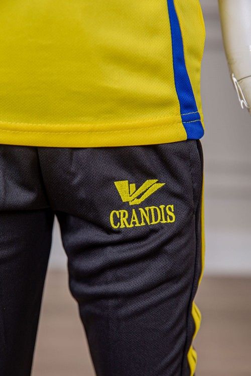 طقم ولادي رياضي قطعتين تيشيرت لون أصفر مقلم باللون الأزرق و بنطلون طويل لون أسود مخطط باللون الأصفر من الجانبين بجيوب و بزم من الأسفل