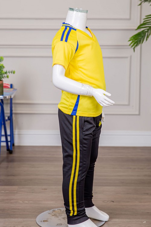 طقم ولادي رياضي قطعتين تيشيرت لون أصفر مقلم باللون الأزرق و بنطلون طويل لون أسود مخطط باللون الأصفر من الجانبين بجيوب و بزم من الأسفل