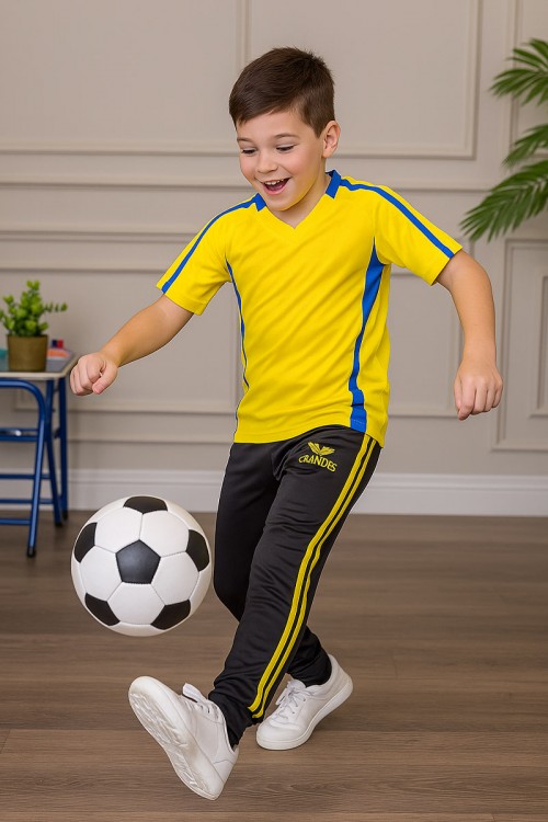 طقم ولادي رياضي قطعتين تيشيرت لون أصفر مقلم باللون الأزرق و بنطلون طويل لون أسود مخطط باللون الأصفر من الجانبين بجيوب و بزم من الأسفل