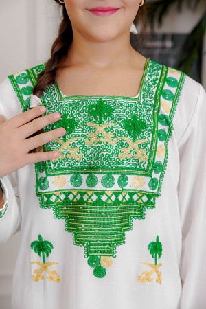 جلابية بناتي لليوم الوطني لون أبيض مزينة بتطريز شعار المملكة العربية السعودية سيفين و نخلة و بياقة مربعة بتطريز تراثي و أكمام طويلة 