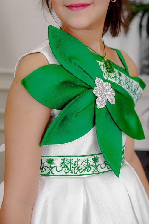 فستان بناتي لليوم الوطني لون أبيض مزين بوردة خضراء و كتابات مطرزة