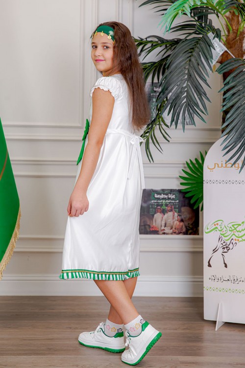 فستان بناتي لون أبيض مزين بتطريز اليوم الوطني ياقة دائرية بأكمام قصيرة و فيونكة من الأمام و رباط من الخلف