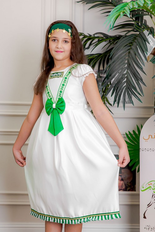 فستان بناتي لون أبيض مزين بتطريز اليوم الوطني ياقة دائرية بأكمام قصيرة و فيونكة من الأمام و رباط من الخلف