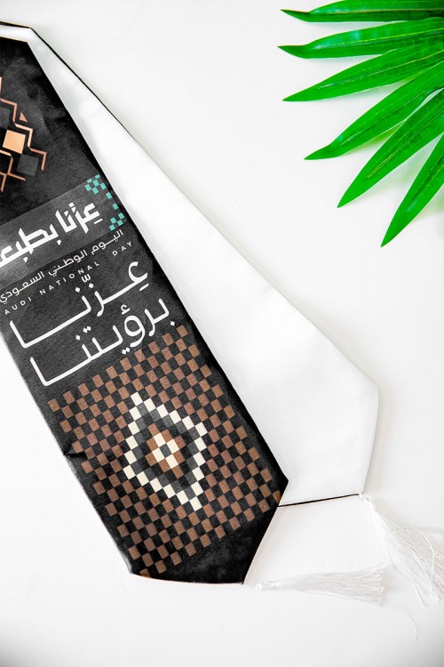 وشاح لون أسود لليوم الوطني بشعار عزنا بطبعنا